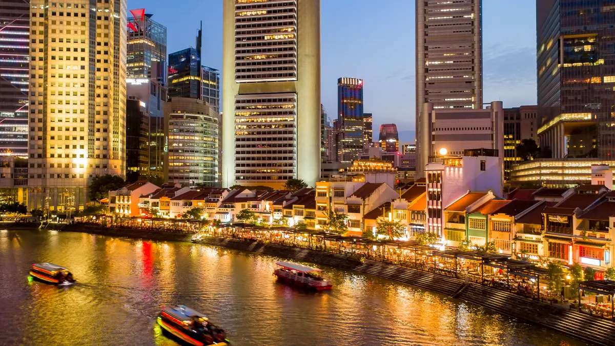 Clarke Quay — The Boat Quay shophouse terrace glowing at dusk beneath the CBD towers, reflected in the Singapore River