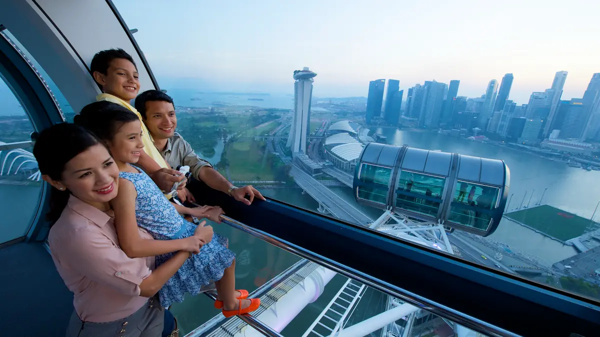 Singapore Flyer — A family looking out over the Singapore skyline from inside a Singapore Flyer capsule